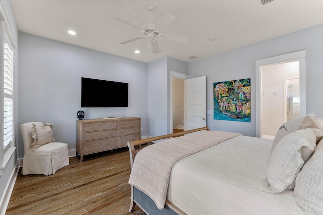 bedroom with hardwood / wood-style floors, connected bathroom, and ceiling fan