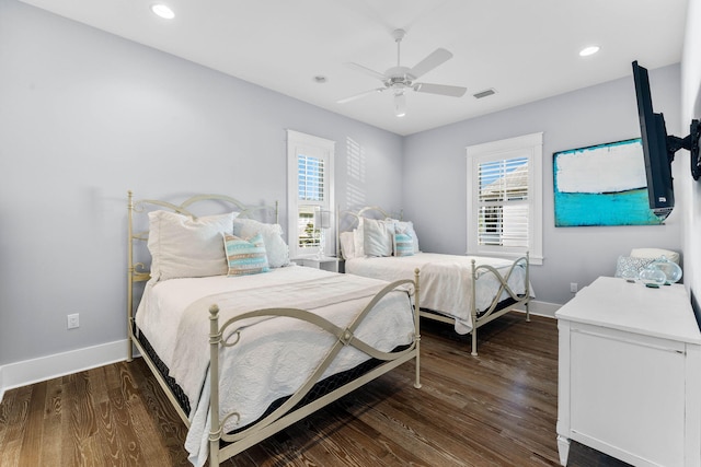 bedroom with dark hardwood / wood-style floors, multiple windows, and ceiling fan