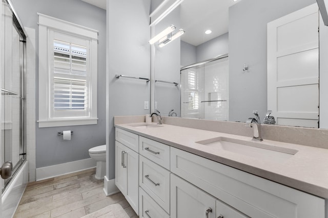 full bathroom with wood-type flooring, vanity, toilet, and enclosed tub / shower combo