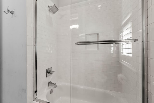 bathroom with combined bath / shower with glass door