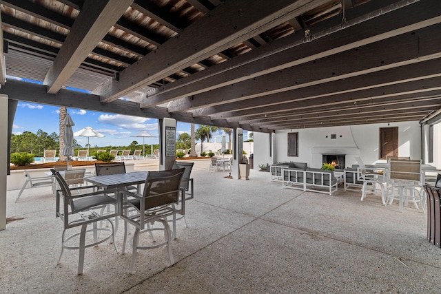 view of patio with exterior fireplace and a swimming pool