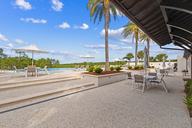 view of patio with a water view and a community pool