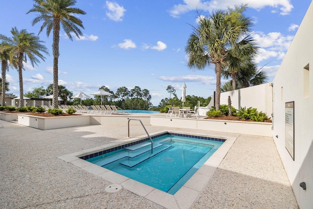 view of pool with a hot tub and a patio area