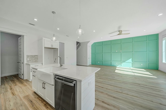 kitchen with dishwasher, white cabinets, sink, hanging light fixtures, and light hardwood / wood-style flooring