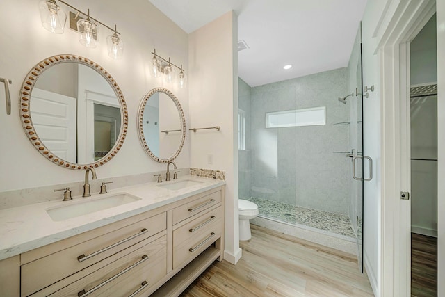 bathroom with vanity, toilet, an enclosed shower, and wood-type flooring