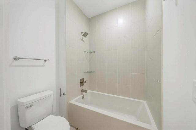 bathroom featuring toilet and tiled shower / bath