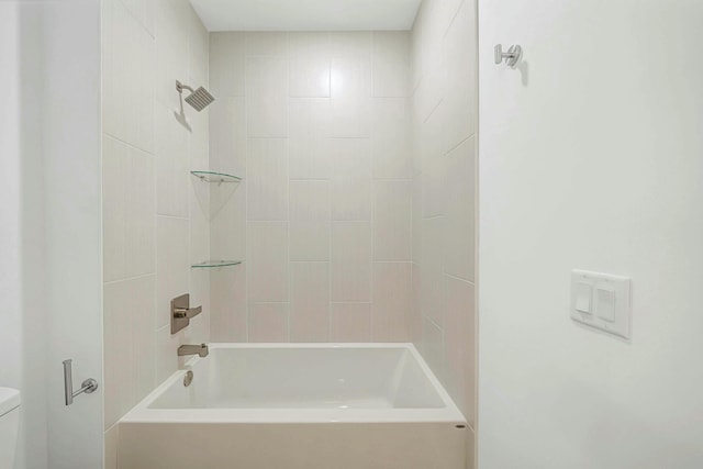 bathroom with tiled shower / bath combo and toilet