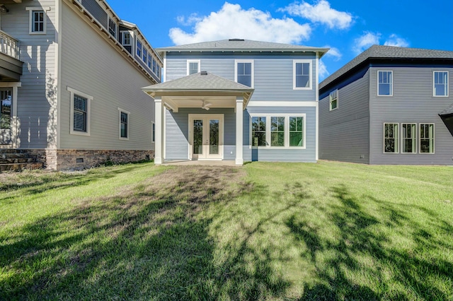 back of property with a yard and french doors