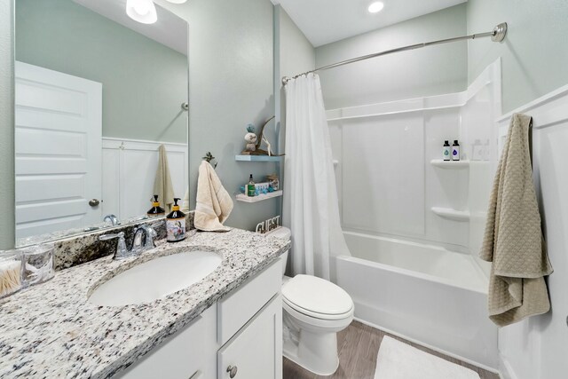 full bathroom featuring vanity, shower / bathtub combination with curtain, wood-type flooring, and toilet