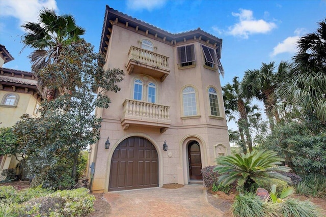 mediterranean / spanish house with a garage and a balcony