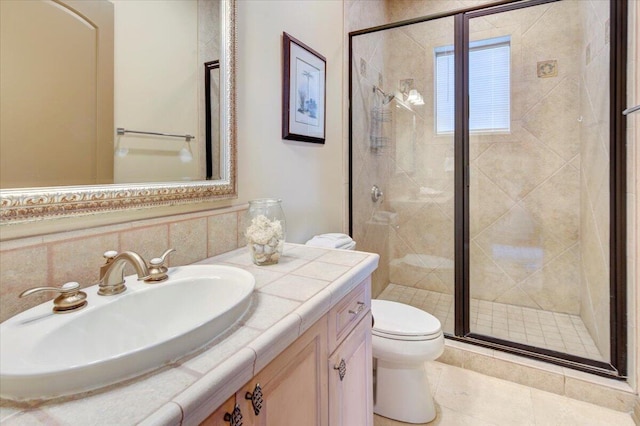 bathroom featuring vanity, tile patterned flooring, toilet, walk in shower, and tile walls