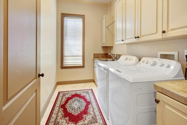 laundry area featuring cabinets, washing machine and dryer, and sink