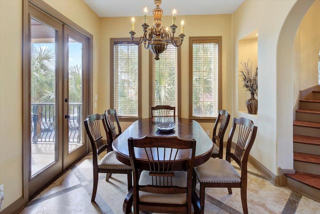 dining space featuring plenty of natural light, french doors, and an inviting chandelier