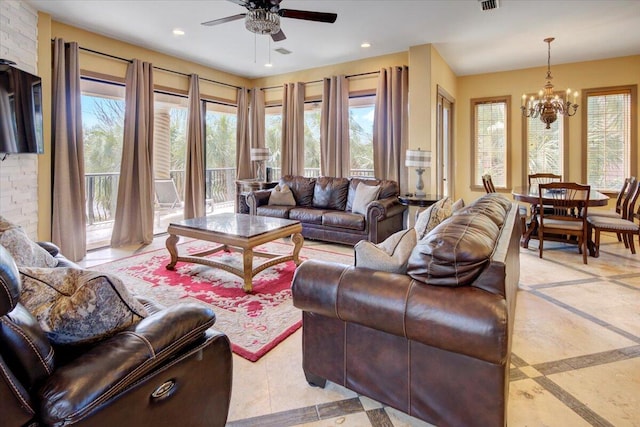 living room featuring ceiling fan with notable chandelier and a wealth of natural light