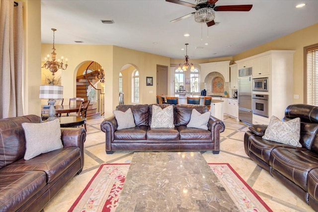 living room featuring ceiling fan with notable chandelier