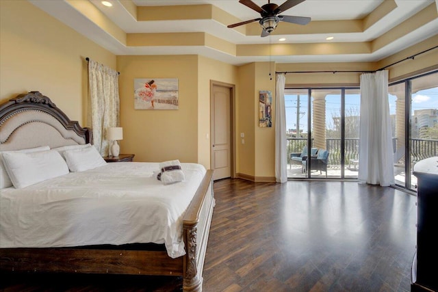 bedroom with a tray ceiling, access to exterior, ceiling fan, and dark hardwood / wood-style floors