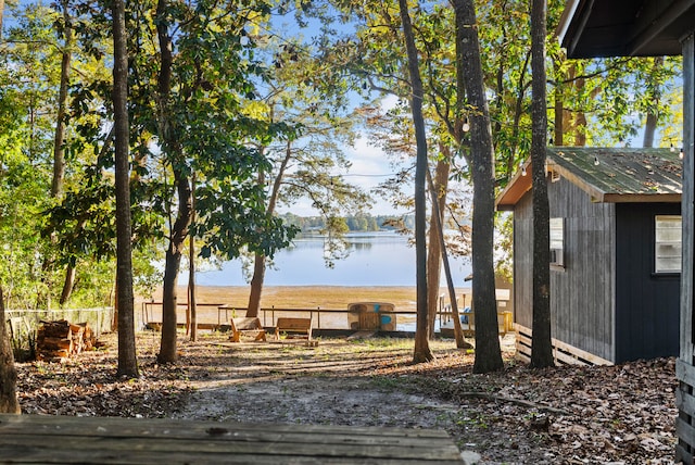 view of yard featuring a water view and a shed