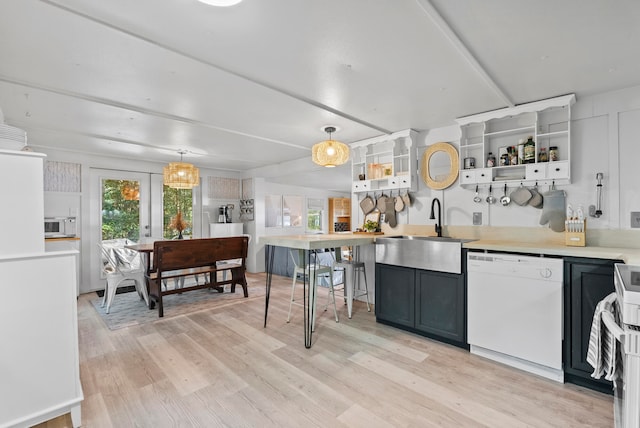 kitchen with french doors, sink, pendant lighting, white appliances, and light wood-type flooring