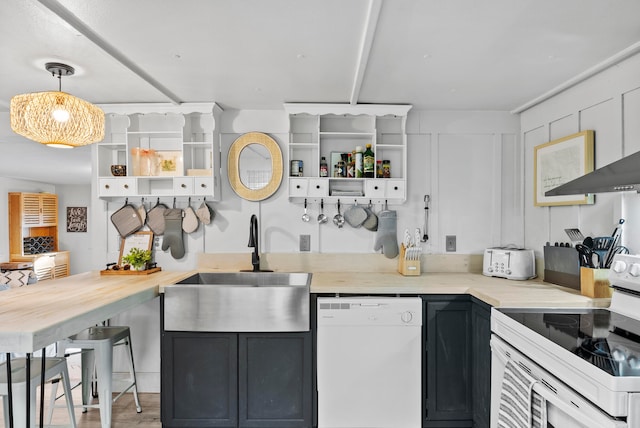 kitchen with white appliances, decorative light fixtures, light hardwood / wood-style flooring, and sink