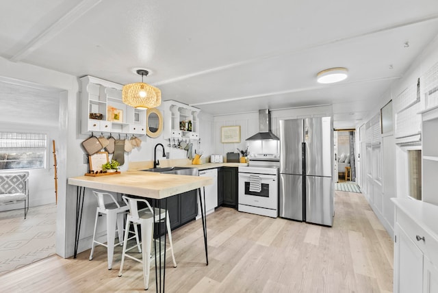 kitchen featuring white cabinetry, sink, wall chimney exhaust hood, hanging light fixtures, and white appliances