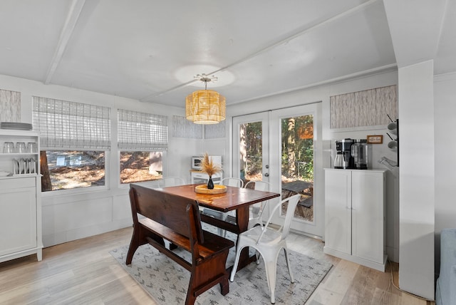 dining area featuring french doors, light wood-type flooring, and a healthy amount of sunlight