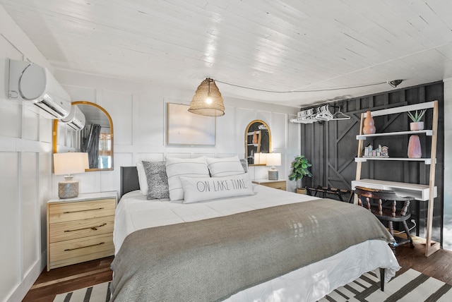 bedroom featuring dark hardwood / wood-style flooring and a wall unit AC