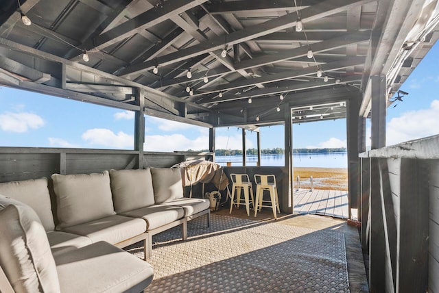 view of patio featuring a water view, an outdoor hangout area, and exterior bar