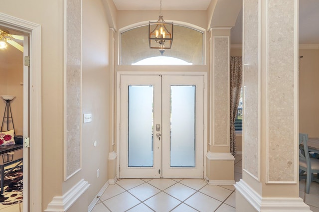 tiled foyer featuring french doors, ceiling fan, and crown molding