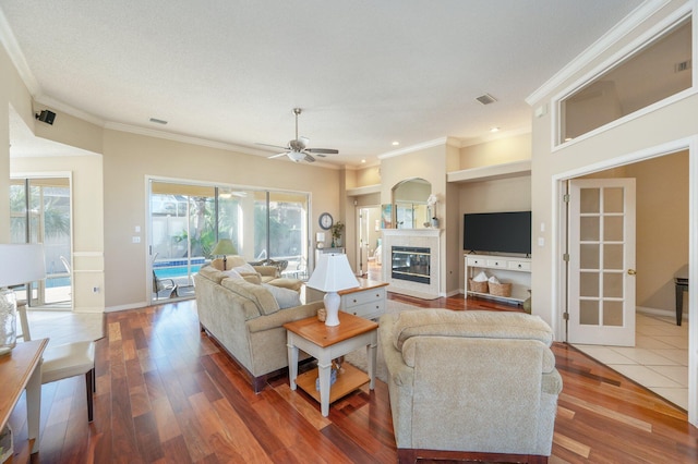 living room with ceiling fan, hardwood / wood-style floors, and ornamental molding