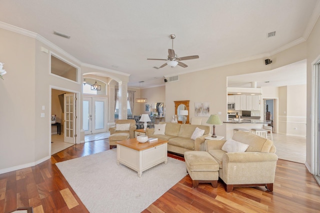 living room with hardwood / wood-style flooring, ceiling fan, crown molding, and french doors