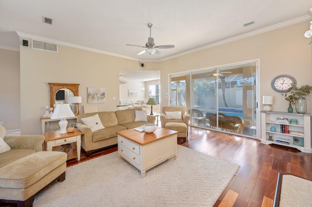 living room featuring wood-type flooring, ceiling fan, and crown molding