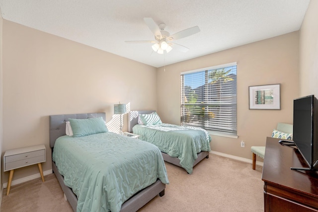 bedroom with a textured ceiling, light colored carpet, and ceiling fan