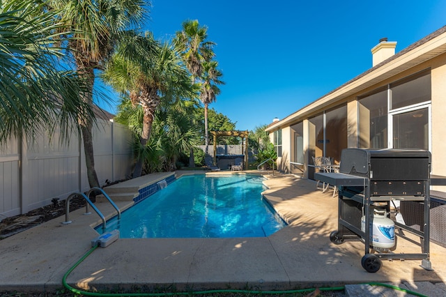 view of pool featuring grilling area, a sunroom, and a patio