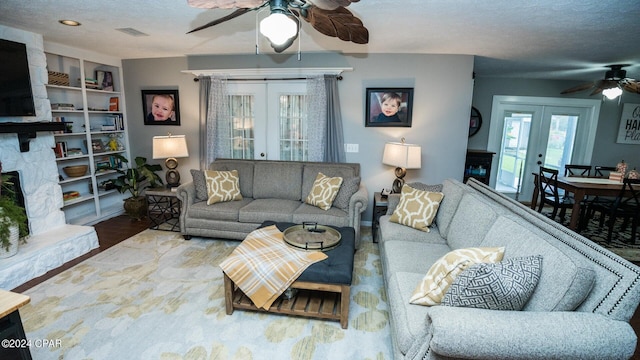 living room featuring french doors, wood-type flooring, and a textured ceiling