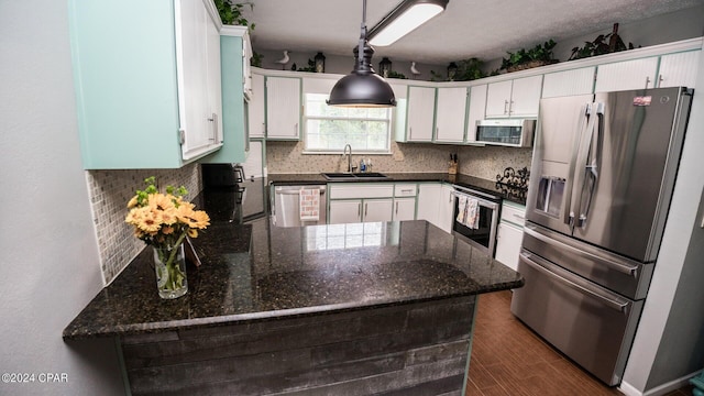 kitchen with dark hardwood / wood-style flooring, white cabinetry, sink, and appliances with stainless steel finishes