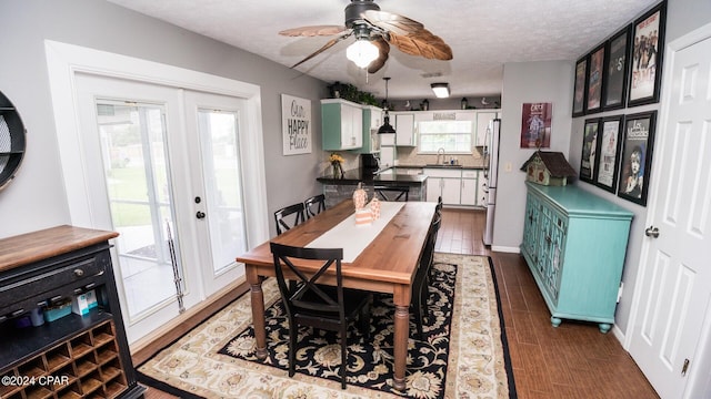 dining area featuring french doors, a textured ceiling, and plenty of natural light