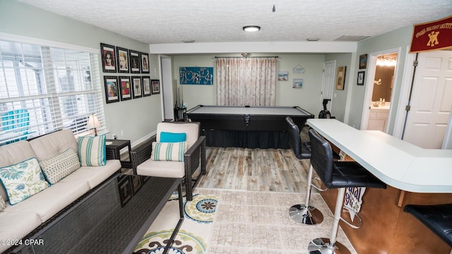 playroom featuring a textured ceiling, light wood-type flooring, and pool table