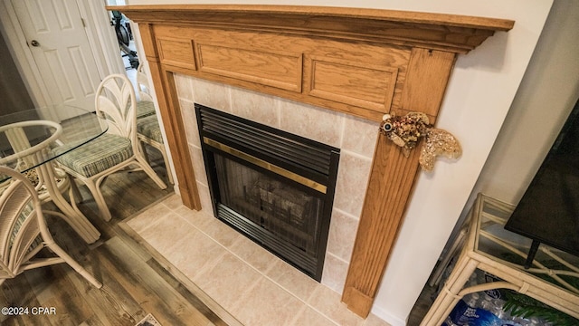 interior details featuring wood-type flooring and a tile fireplace