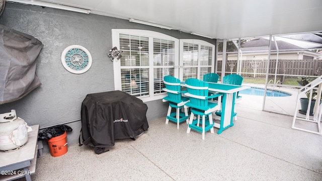 view of patio / terrace featuring a fenced in pool, glass enclosure, and grilling area