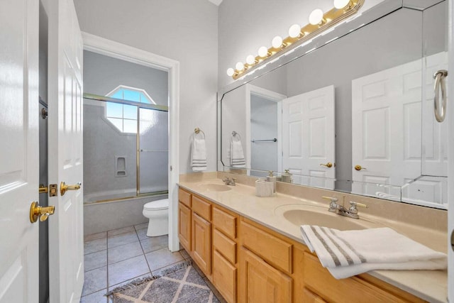 full bath featuring double vanity, tile patterned flooring, combined bath / shower with glass door, and a sink