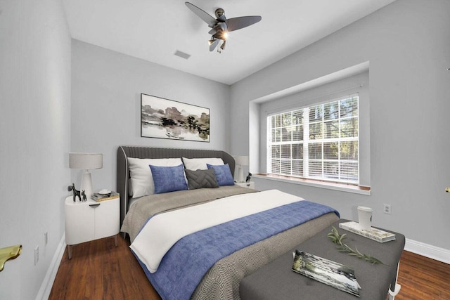 bedroom featuring dark wood-type flooring, a ceiling fan, visible vents, and baseboards