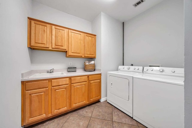 laundry room with visible vents, cabinet space, washing machine and dryer, light tile patterned flooring, and a sink