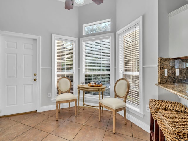 sitting room featuring light tile patterned floors, baseboards, and a ceiling fan