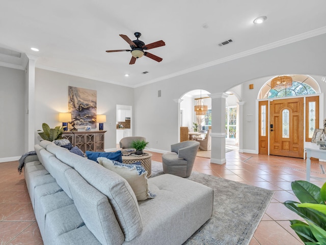 living area featuring arched walkways, crown molding, visible vents, light tile patterned flooring, and ornate columns