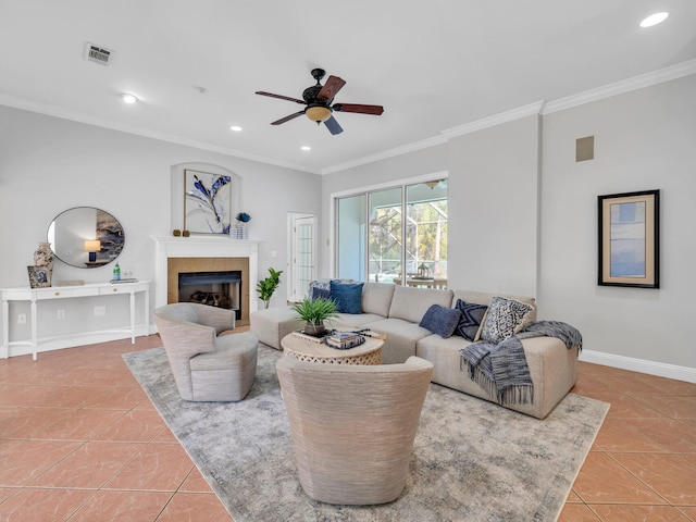 tiled living room with recessed lighting, visible vents, baseboards, ornamental molding, and a glass covered fireplace