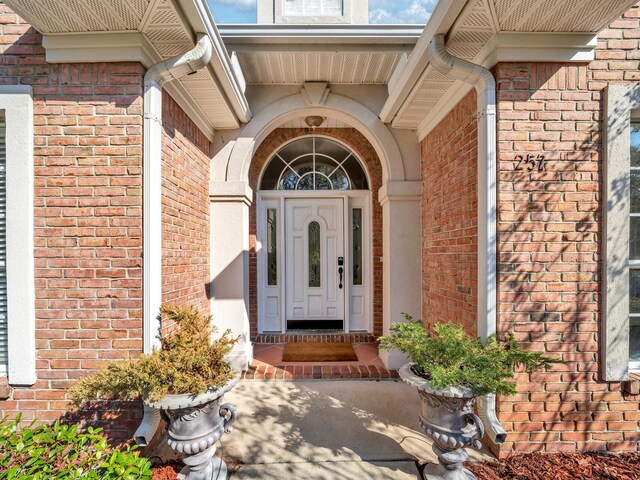 entrance to property featuring brick siding