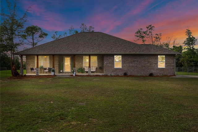 back house at dusk with a yard and a patio