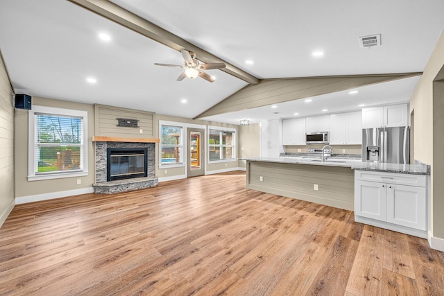 kitchen with stainless steel appliances, white cabinetry, and plenty of natural light