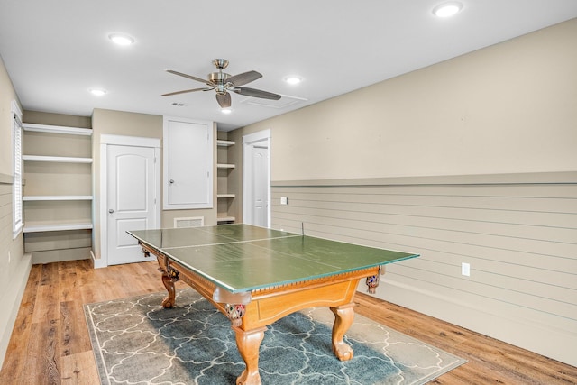 playroom featuring light hardwood / wood-style floors, ceiling fan, and wood walls