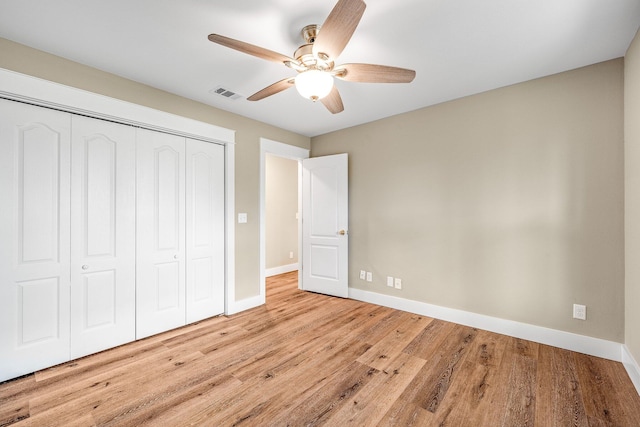 unfurnished bedroom with a closet, light hardwood / wood-style flooring, and ceiling fan